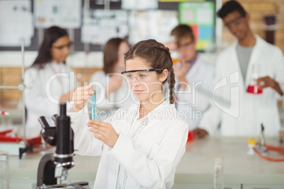 Attentive schoolgirl doing a chemical experiment in laboratory