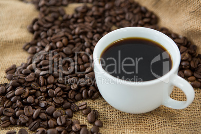Cup of black coffee and roasted coffee beans