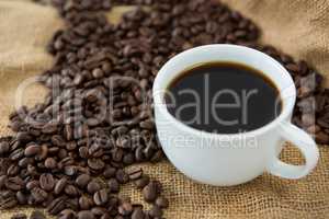Cup of black coffee and roasted coffee beans