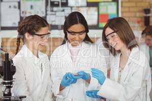 Smiling schoolgirls doing a chemical experiment in laboratory
