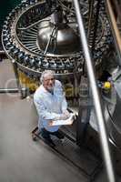 Factory engineer monitoring filled juice bottle on production line