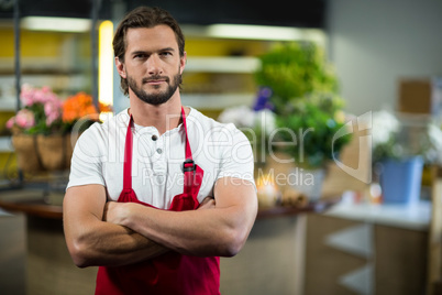 Florist standing in florist shop with arms crossed