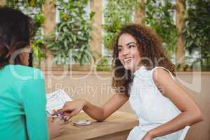 Two female business executives interacting with each other at desk