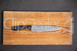 Knife on wooden board