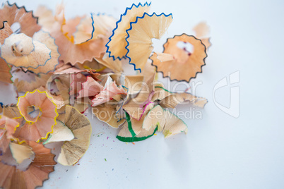 Colored pencils shavings on a white background