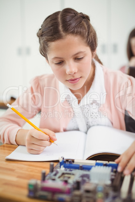 Schoolgirl working on electronic project in classroom