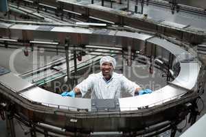 Factory engineer standing next to production line