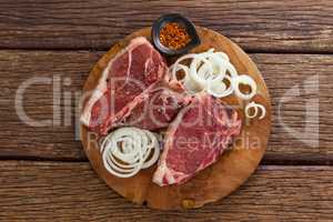 Blade chop, onions and spices on wooden round tray