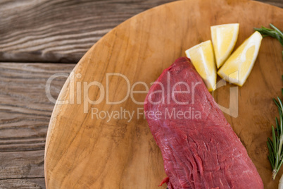 Beef steak, lemon and rosemary herb on wooden tray