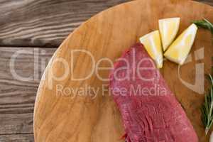 Beef steak, lemon and rosemary herb on wooden tray