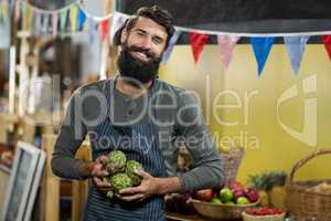 Vendor holding custard apples at the grocery store