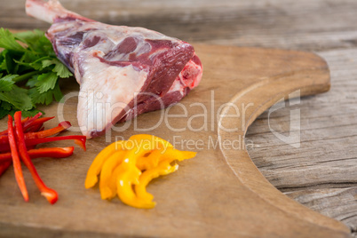 Rib chop, bell pepper and corainder leaves on wooden tray against wooden background