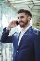 Businessman talking on mobile phone at railway station