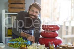 Portrait of salesman arranging cheese at counter