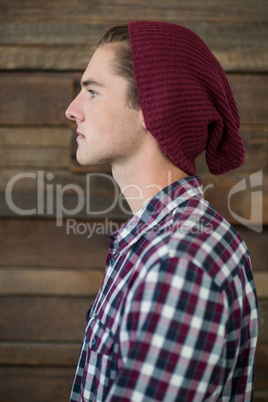 Side view of business executive standing against wooden wall