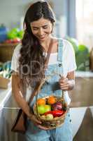 Smiling woman holding a basket of fruits