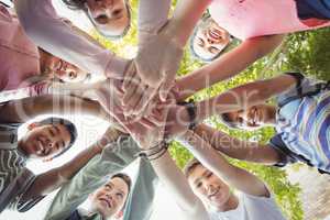 Happy school kids forming hand stack in campus