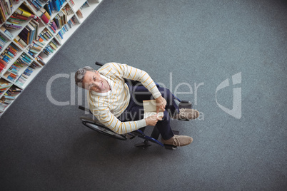 Overhead view of disabled school teacher holding book in library