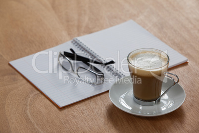 Cup of coffee with spectacles and organizer