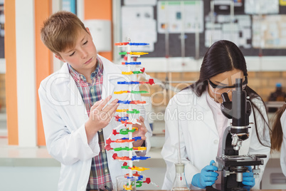 School kids experimenting molecule model in laboratory