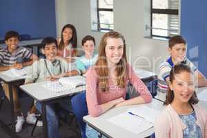 Portrait of smiling school kids sitting in classroom