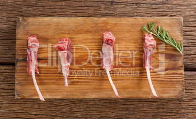 Rib chops and rosemary herb on wooden tray