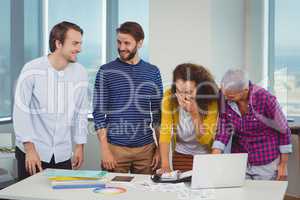 Smiling graphic designers interacting with each other