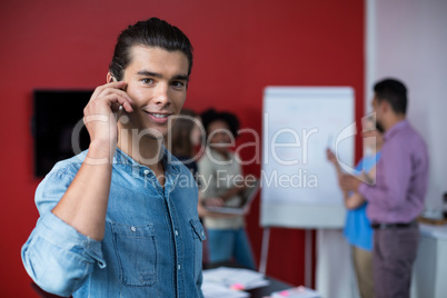Business executive talking on mobile phone at meeting