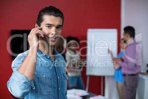 Business executive talking on mobile phone at meeting