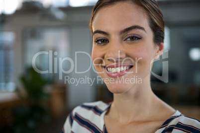 Smiling female executive standing in creative office