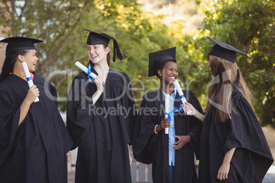 Graduate school kids standing with degree scroll in campus at school