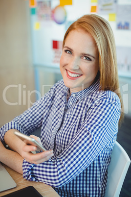 Portrait of female graphic designer holding mobile phone