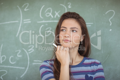 Thoughtful schoolgirl pretending to be a teacher in classroom