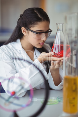 Attentive schoolgirl doing a chemical experiment in laboratory