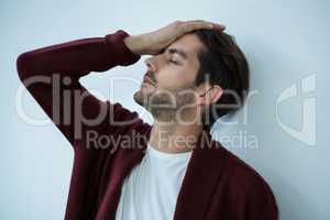 Stressed man leaning on wall