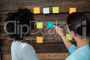 Female graphic designer pointing at sticky notes