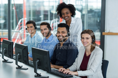 Portrait of smiling business executives working on computer