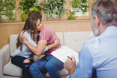 Couple embracing each other while consulting doctor