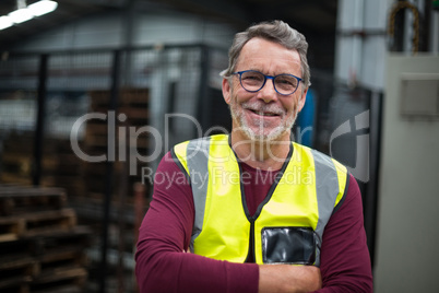 Portrait of male factory worker standing with arms crossed