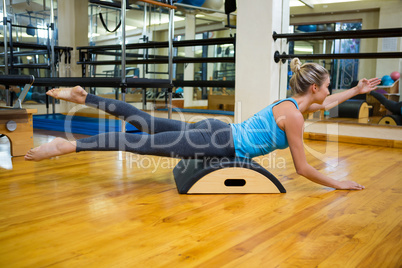 Determined woman exercising on arc barrel