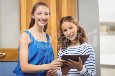 Students holding digital tablet in classroom