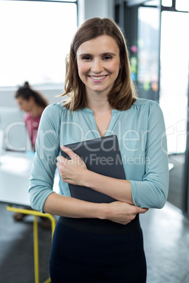 Business executive standing with digital tablet in office