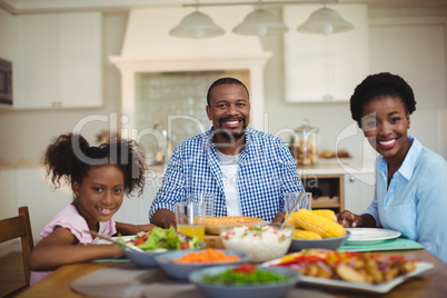 Portrait of family having meal on dinning table at home