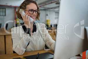 Woman talking on landline phone at desk