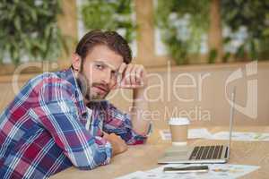 Portrait of tensed executive with laptop siting at desk