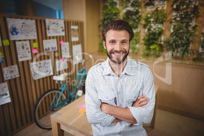 Portrait of smiling male business executive standing with arms crossed