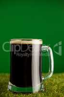 Mug of green beer on grass for St Patricks Day