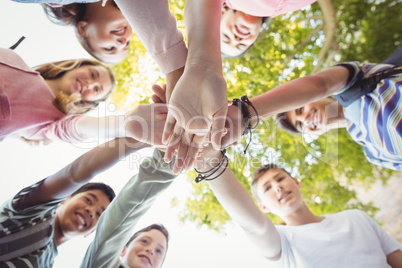 Happy school kids forming hand stack in campus