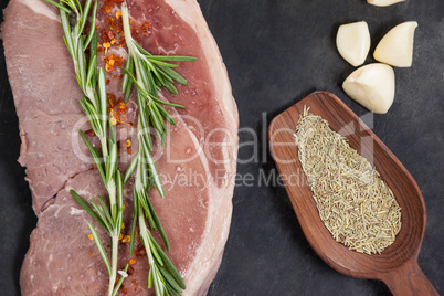 Sirloin chop, garlic and spices on black slate plate