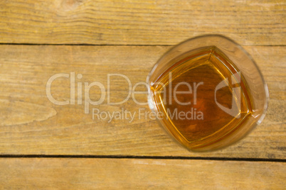 Glass of whisky on wooden table